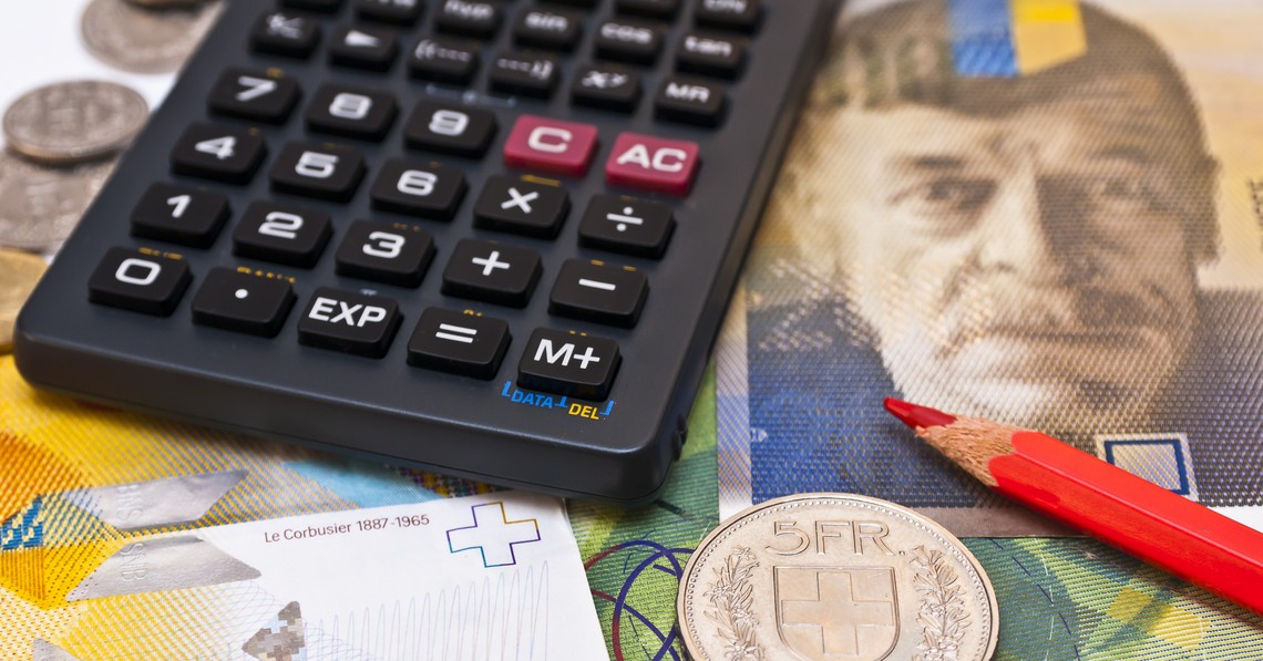 Symbolbild Produzenten- und Importpreisindex, Taschenrechner, roter Bundstift und fünf Franken Münze liegen auf Schweizer Banknoten