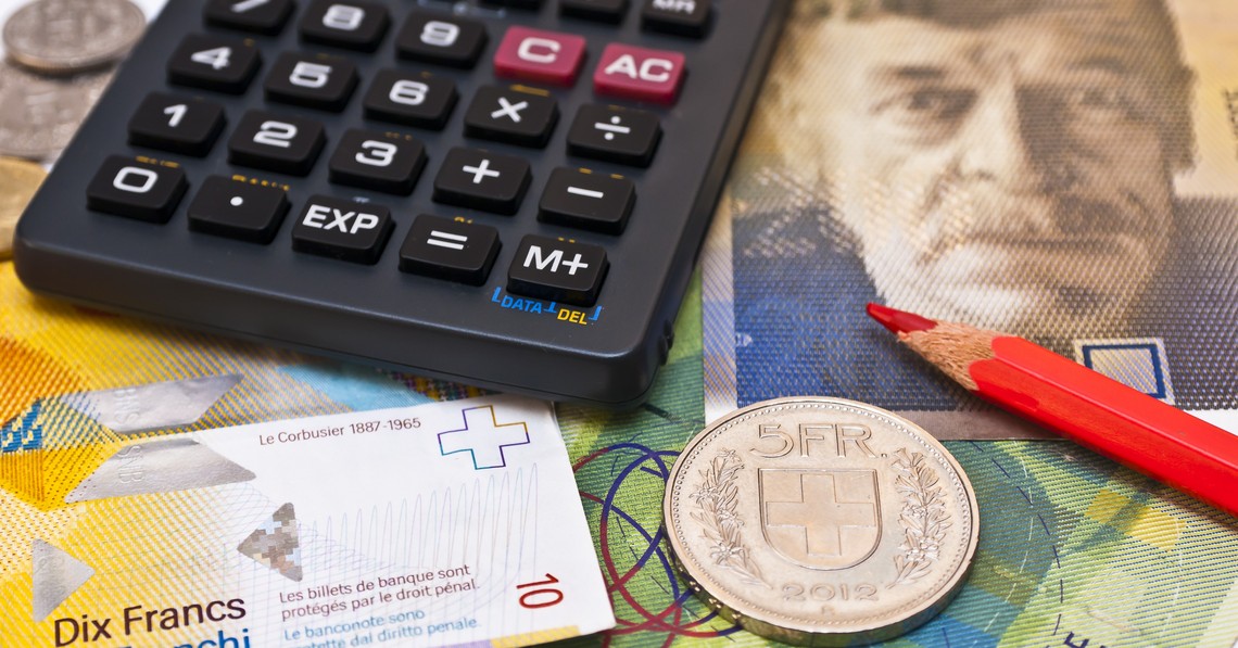 Symbolbild Produzenten- und Importpreisindex, Taschenrechner, roter Bundstift und fünf Franken Münze liegen auf Schweizer Banknoten